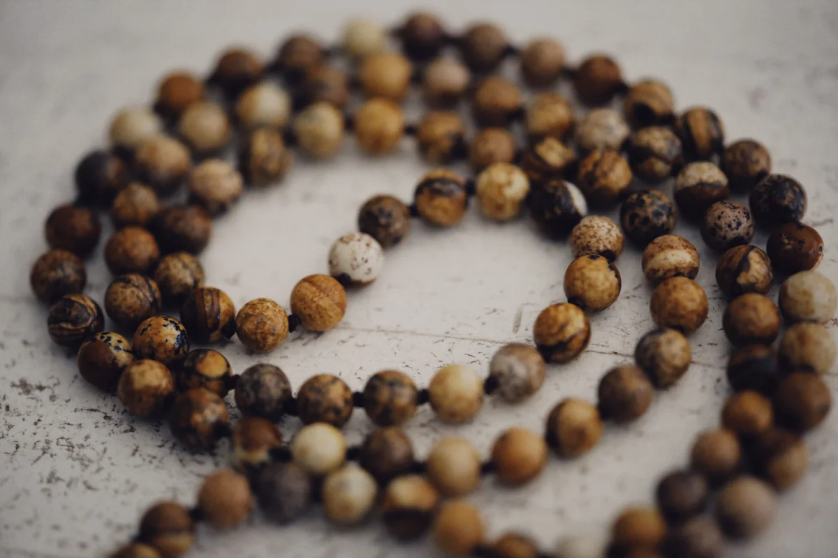 A necklace of rounded brown and beige beads on a pale surface.
