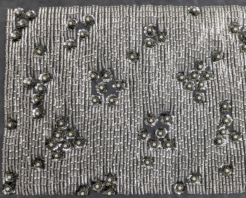Pale vertical reflective lines interrupted by clusters of small dark flowers.