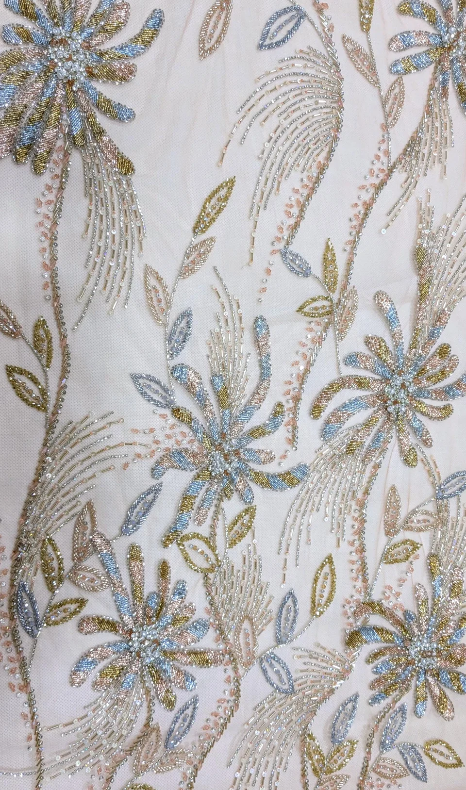 Pale blue, green and blush floral motifs with long flowing reflective lines on a light ground.